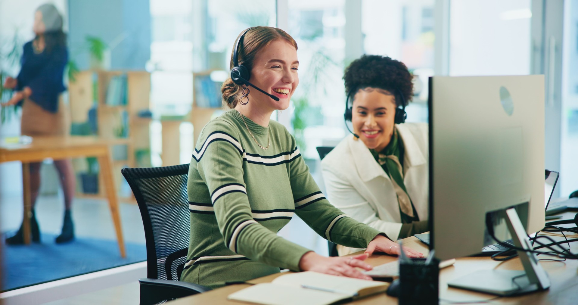 Happy, people and headset with computer in call centre of communication, customer service and ecommerce. Women, teamwork and talking with mic for telemarketing advice, website faq and online solution